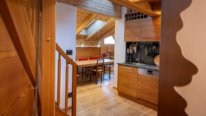 Un interior de madera con una zona de cocina, una mesa de comedor y sillas.