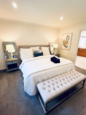 Relax in comfort with a large bed, bedside table, and framed artwork.