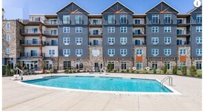 Un hôtel à plusieurs étages doté d’un espace piscine.
