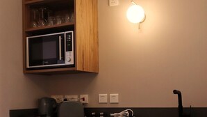 A kitchen with wooden cabinets, a microwave, a toaster, and a sink. - Tranquil studio with AC in Rabat - Studio No.2  (Rabat)