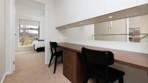 Une chambre moderne avec une grande fenêtre, un lit et un bureau avec des chaises.