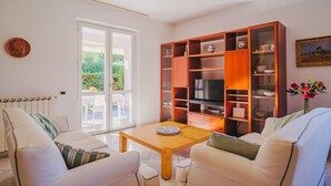 A living room with a sofa, a wooden coffee table, and a bookshelf. - Lucerna Due by Interhome (Ameglia)