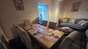 Et spiseområde med et træbord, fire stole og et gulv med ternet mønster.