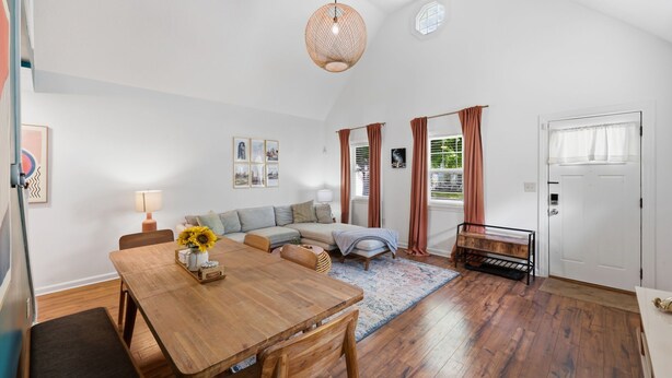 A cozy living room with a sofa, a dining table, and a hanging light fixture. - Coffee Lover's Paradise - Heart of Tremont (Cleveland)