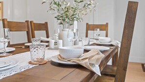 Tavola imbandita con piatti, bicchieri e un vaso di fiori.