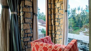 A room with a stone wall and a view of a garden. - Outstanding  3BR villa at 50 m away from the white-sand of Hoi An beach. (phường Cẩm An)