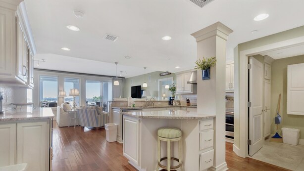 A spacious kitchen with a large island, white cabinetry, and a view to the outside.