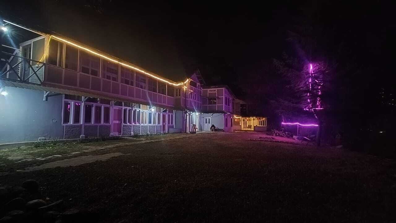 En bygning med et overdækket gelænder og et stort åbent område foran.