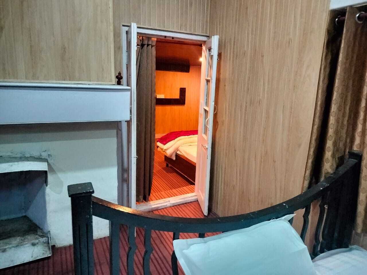 A room with a bed, a wooden door, and a red carpet.