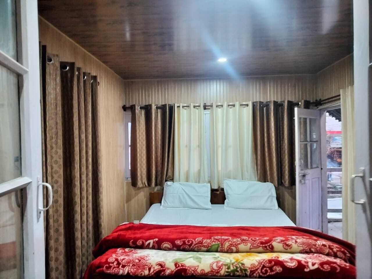 A bedroom with a bed, curtains, and a door.