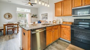A kitchen with wooden cabinets, a stainless steel dishwasher, a black oven, and a granite countertop. - 4 Mi to Ocean: Modern Townhome in Wilmington! (Wilmington)