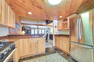 Una cocina amplia con armarios de madera, un refrigerador de acero inoxidable y una isla grande.