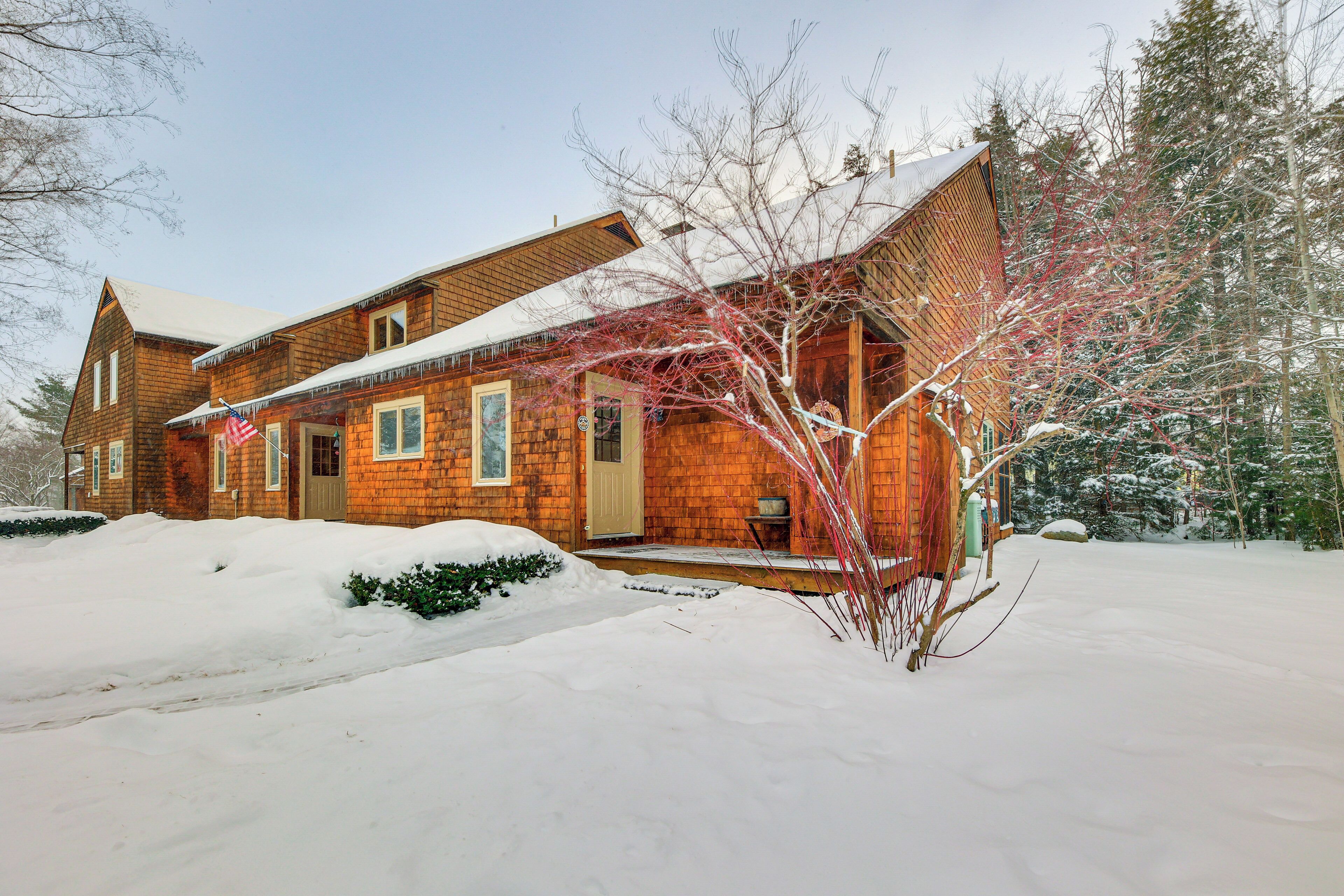 A wooden house with a snow-covered roof and a front porch.