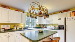 A kitchen with white cabinets, a green countertop, a chandelier, and a refrigerator. - 30 Acres of Mountainside Peace: Home in Marble (Marble)