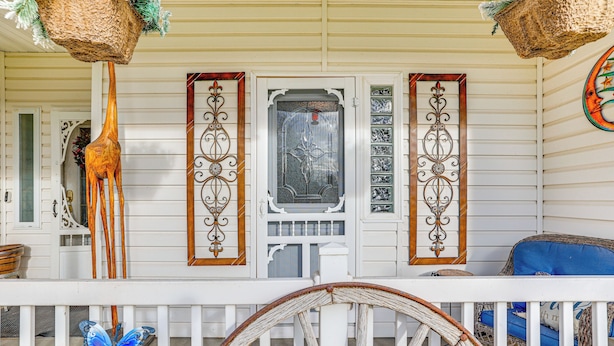 A porch with a decorative wooden giraffe, a welcome sign, and a vintage wagon wheel. - Hidden Gem in the Heart of Old Town Meridian (Meridian)