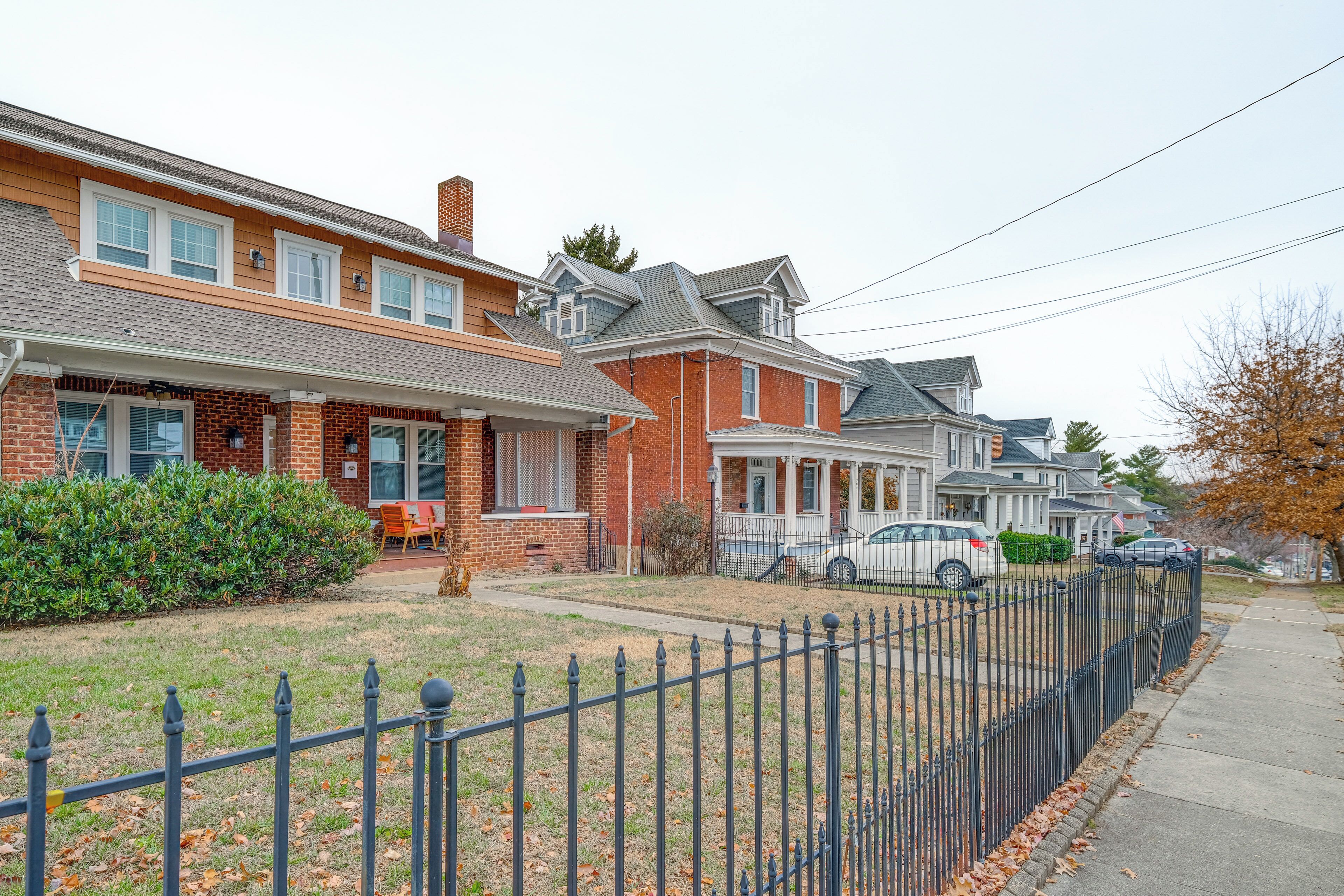 A row of brick houses with a black metal fence in front.