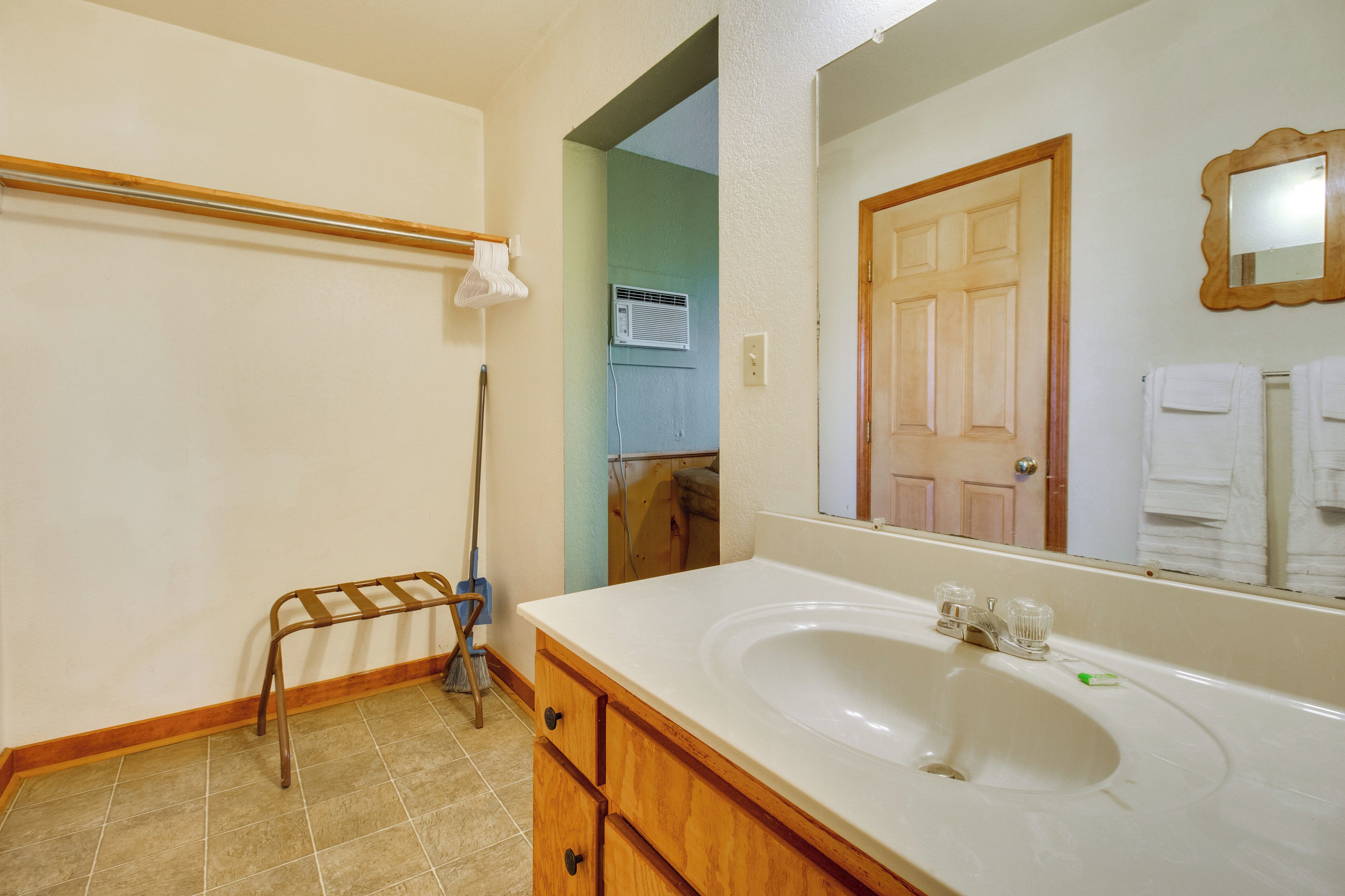 Une salle de bain avec un lavabo blanc, un meuble-lavabo en bois et un miroir.