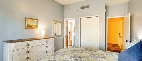 Une chambre à coucher avec un lit, une commode et un ventilateur de plafond.