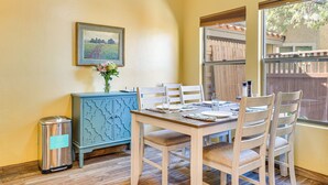 A dining area with a wooden table, white chairs, a blue cabinet, and a trash can. - 12 Mi to Dtwn Tucson: Tranquil Townhome w/ Office (Tucson)