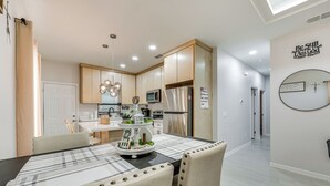 Een moderne keuken met houten kastjes, roestvrijstalen apparatuur en een centraal kookeiland met decoratieve decoratie.