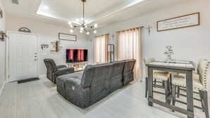 Een moderne woonkamer met een bank, een eettafel en een televisie.