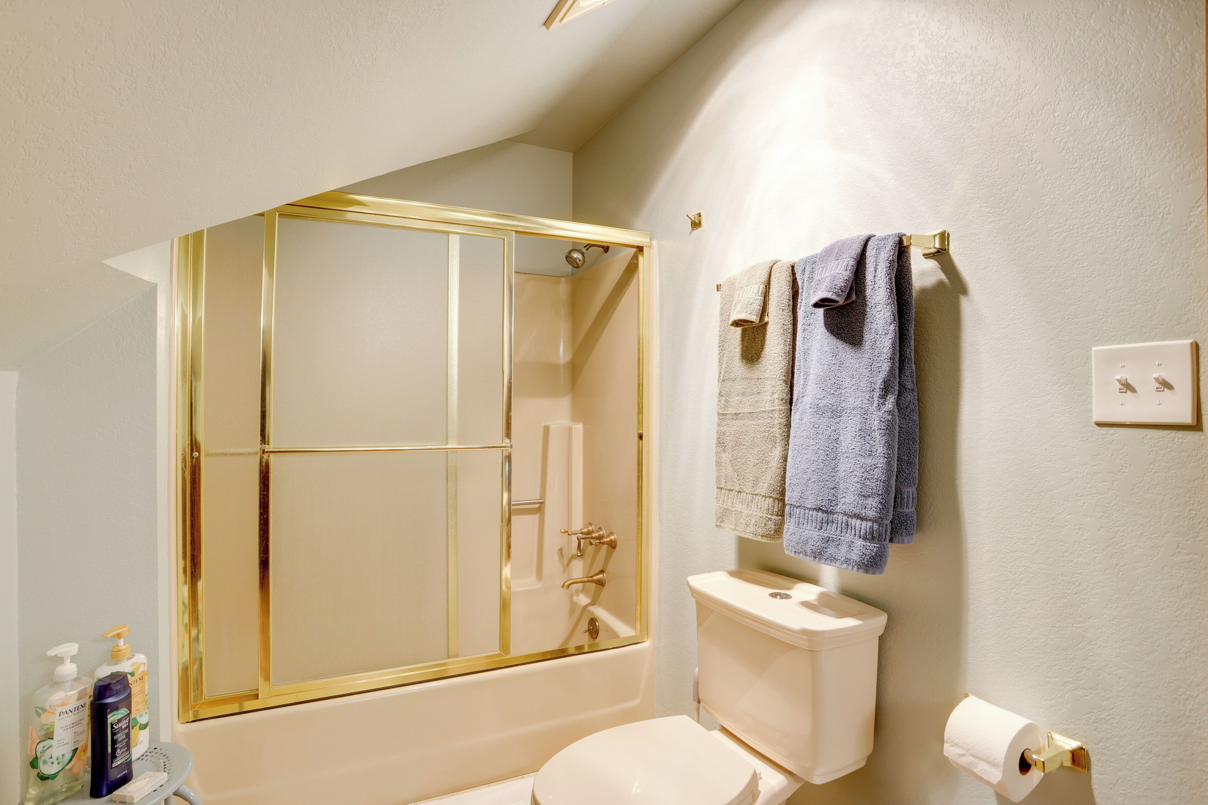 Un bagno con vasca, servizi igienici e uno specchio con cornice dorata.