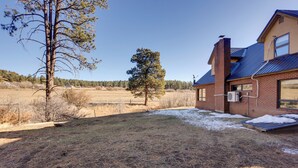 A house with a brick exterior, a metal roof, and a yard with sparse grass and a few trees. - Near Hiking: Mtn-view Getaway in Bayfield! (Bayfield)