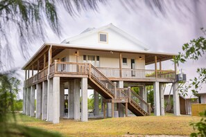 A two-story house with a balcony and a staircase leading to the upper level. - Starlight Serenity - Hideaway w Stunning Views (Summerland Key)