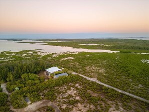 An aerial view of a coastal area with a small building surrounded by dense vegetation and a road leading to it. - Starlight Serenity - Hideaway w Stunning Views (Summerland Key)