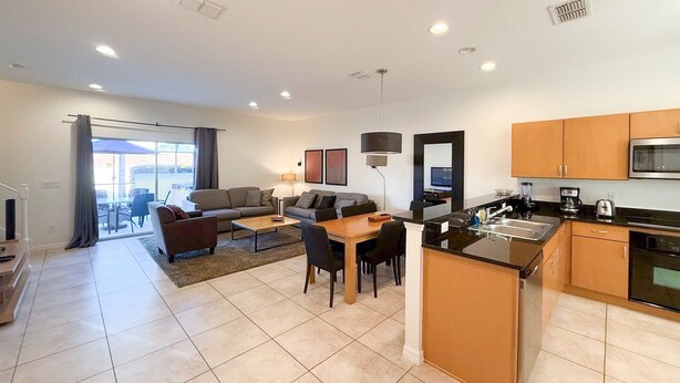 A modern apartment with a living area, dining space, and kitchen. - Upstay Spacious 3BR Home w Resort Access (Kissimmee)