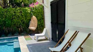 Una piscina con due lettini e un'amaca.