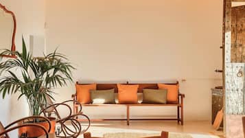A cozy living room with a wooden bench, a potted plant, and a rustic door.