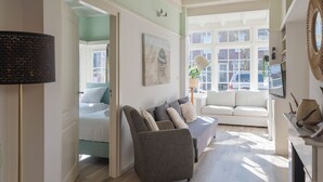Un salon moderne avec un canapé, un lit et un téléviseur.