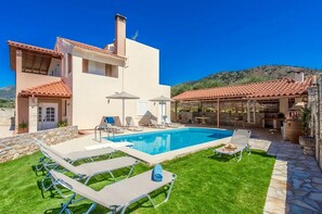 A two-story house with a swimming pool, outdoor seating, and a stone wall. - Villa Korini With Swimming Pool (Mylopotamos)