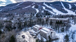 A modern building with a flat roof and a parking lot in a snowy landscape. - Slopeside! Cascades studio Sleeps 5 (Newry)