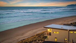 Ein Strandgrundstück mit modernem Design, ausgestattet mit einer Flachdach und einem Balkon mit Meerblick.