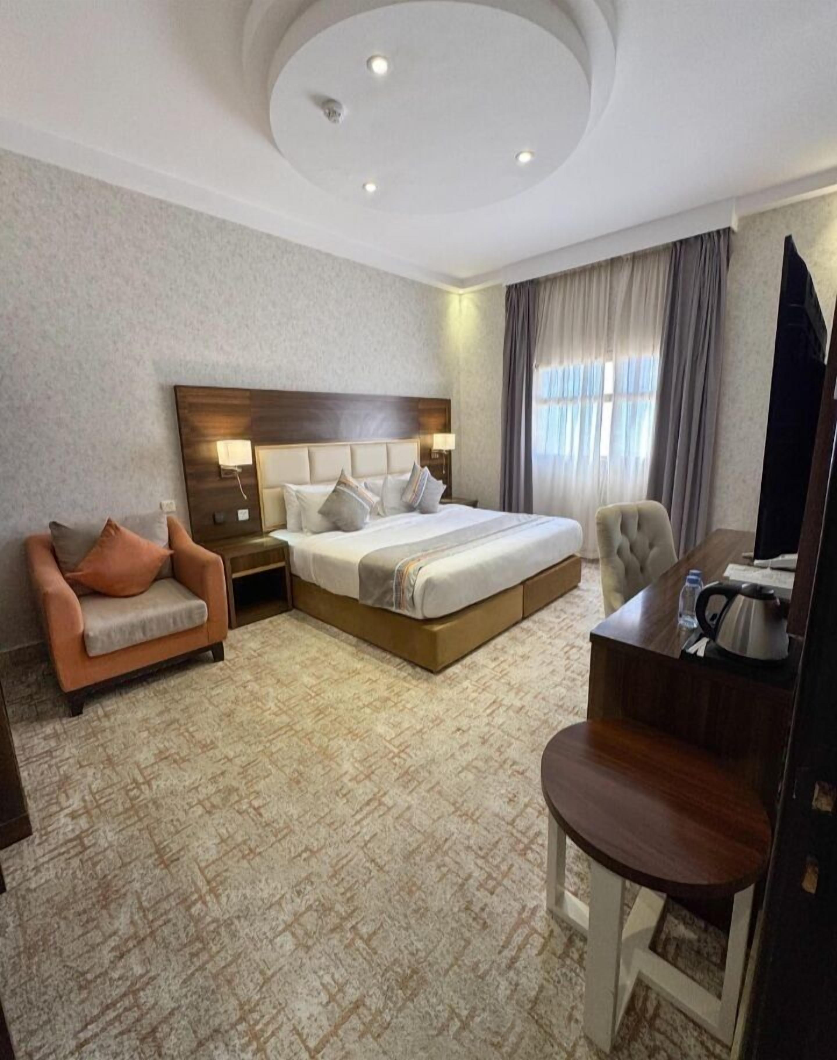 Une chambre d’hôtel avec un grand lit, un canapé, un bureau et une télévision.