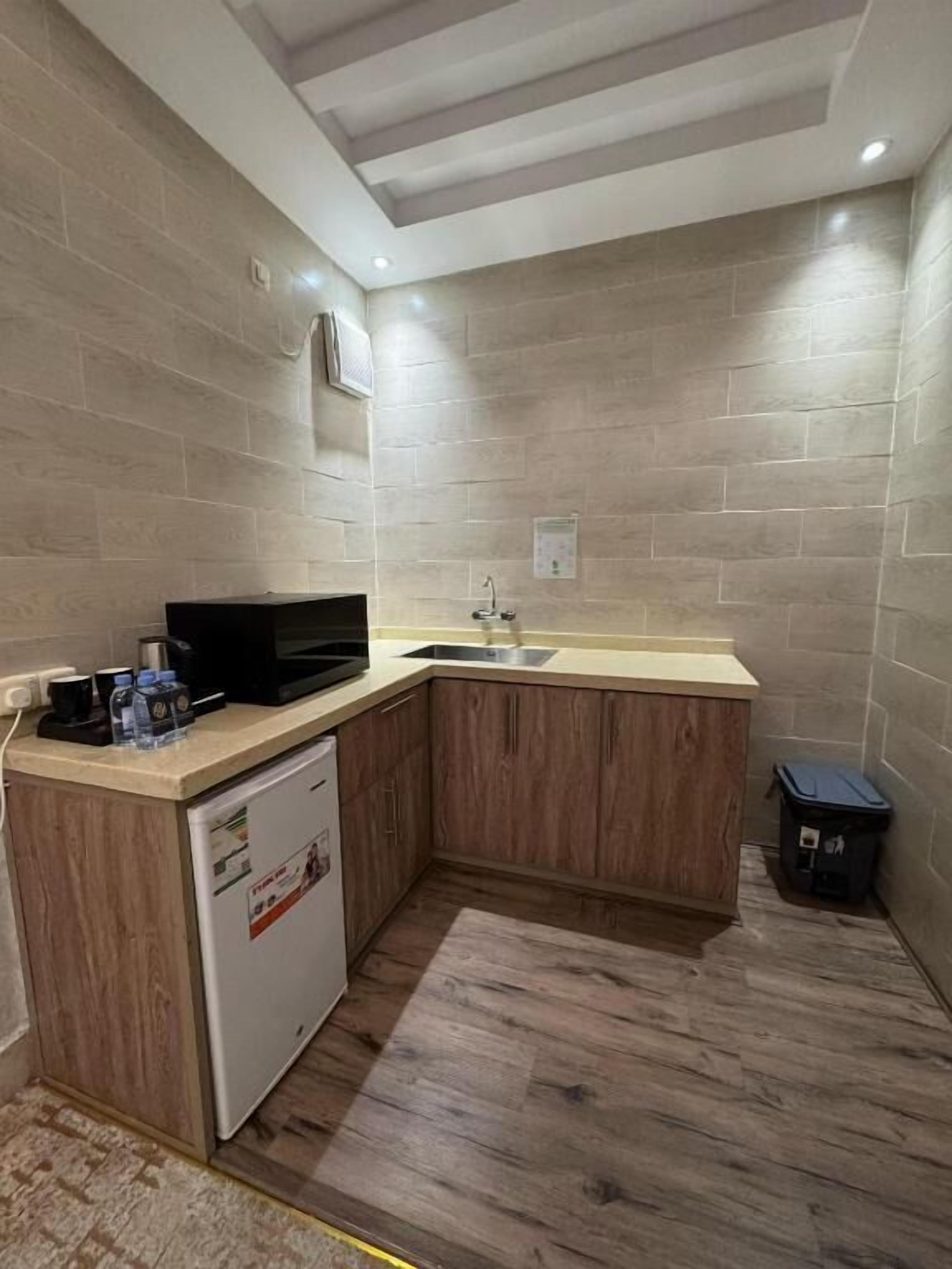 A compact kitchen with a microwave, sink, and refrigerator.
