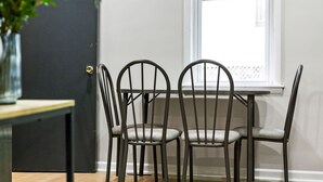 A dining area with a table and four chairs, a door, and a window with a view. - Colorful 5BR 3BA in Oakland, near Pitt & CMU (Pittsburgh)