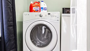 A front-loading washing machine with detergent bottles on top. - Colorful 5BR 3BA in Oakland, near Pitt & CMU (Pittsburgh)