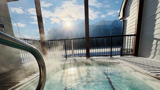 Una piscina cristalina con vistas a montañas al fondo.