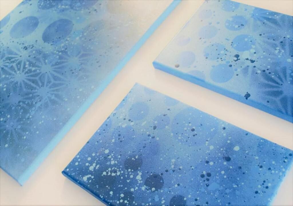 Trois panneaux de verre peints en bleu, ornés d’un motif éclaboussé.