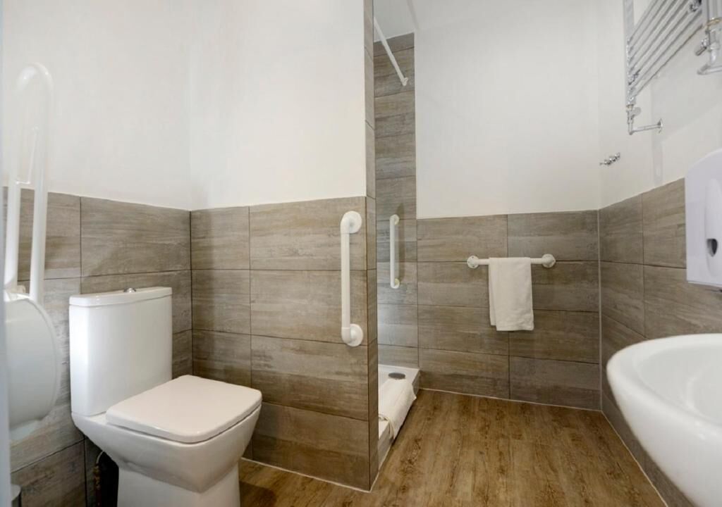 Un baño moderno con inodoro, ducha y lavamanos.