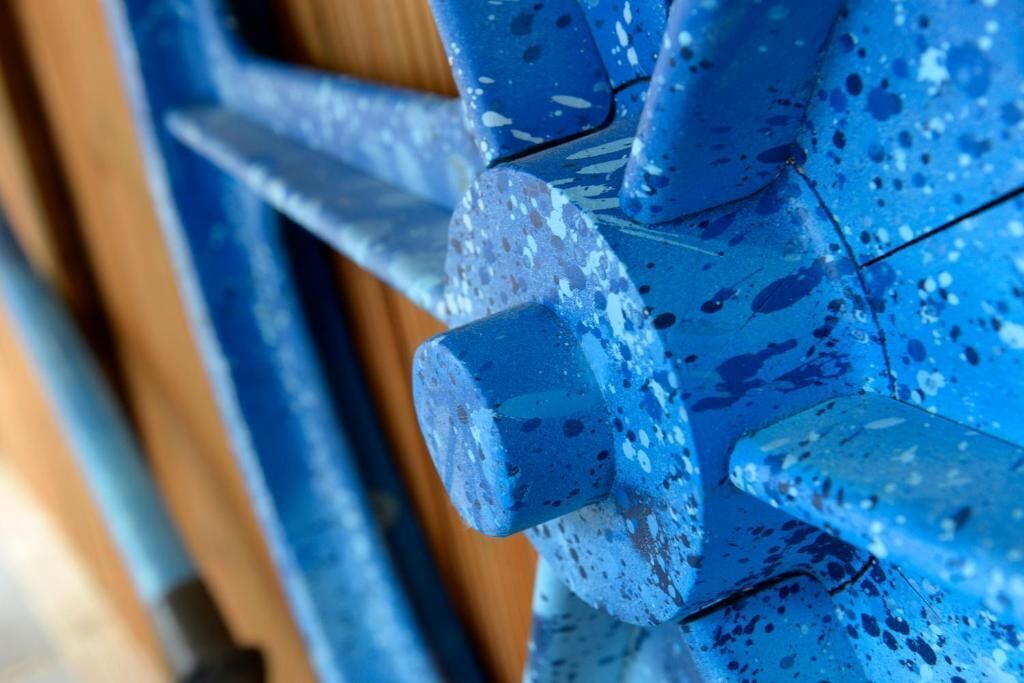 Een close-up van een blauw metalen hekwerk met een structuur.