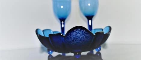 A set of blue glassware on a reflective surface.