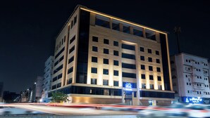 Un hôtel moderne doté d’une entrée imposante, de plusieurs étages et d’une enseigne bien visible indiquant qu’il s’agit d’un hôtel Mirada.