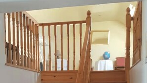 Eine Holztreppe mit Handlauf, die zu einer oberen Etage führt.