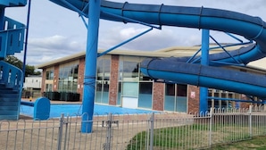 A water park with blue slides and a building with large windows. - Highfield Grange Holiday Park (Clacton-on-Sea)
