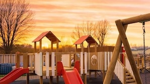 A playground with slides and a swing set. - Highfield Grange Holiday Park (Clacton-on-Sea)
