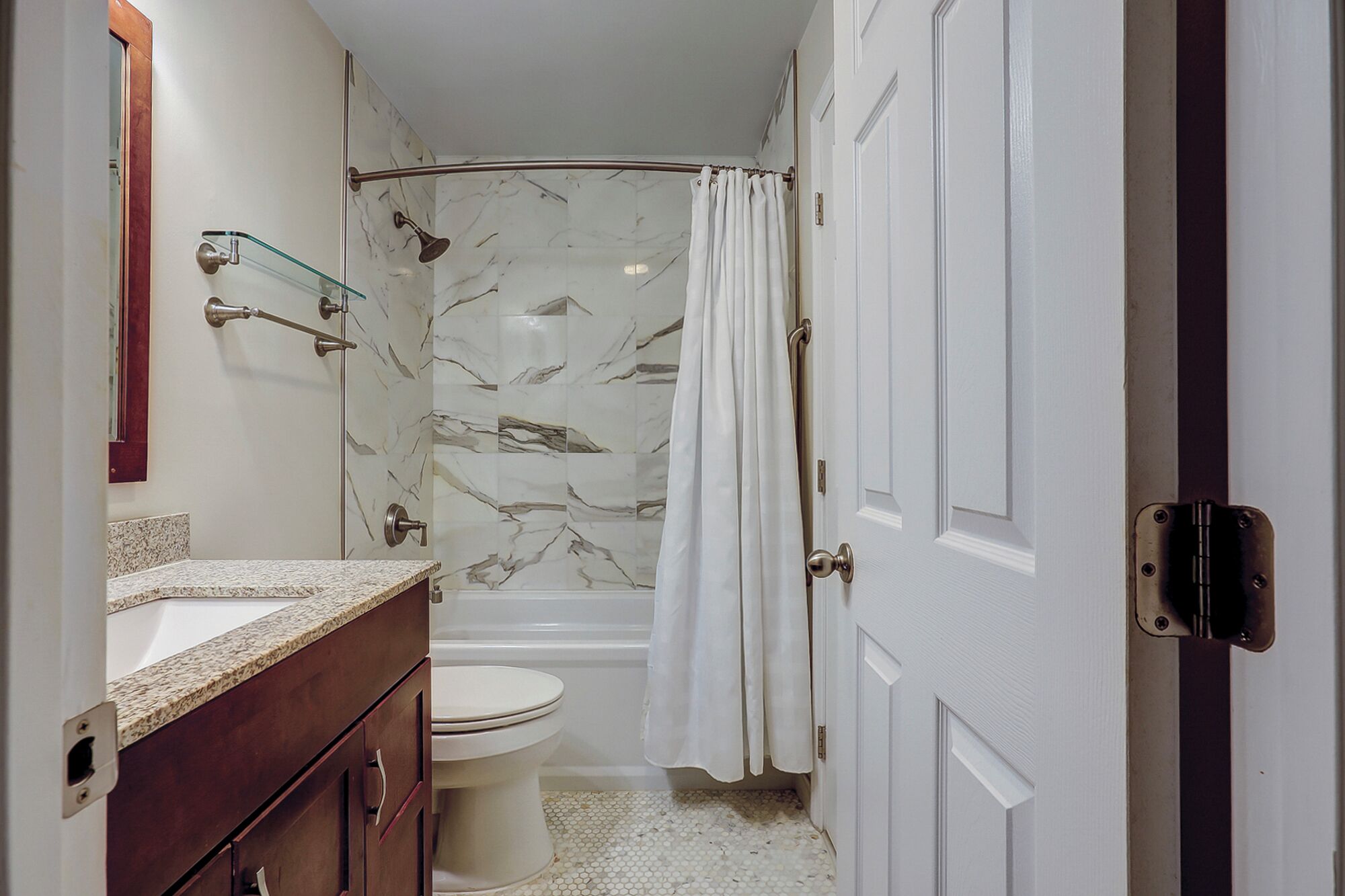 A bathroom with a shower, toilet, and vanity.